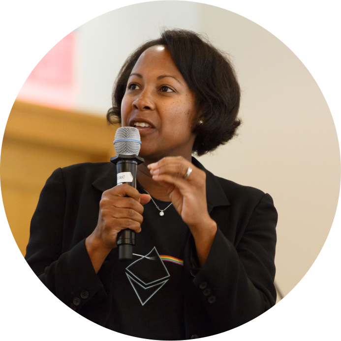 A woman dressed in black holds a microphone